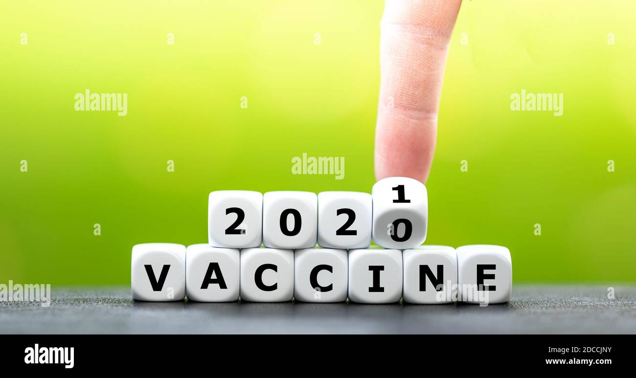 Símbolo de una vacuna covid en 2021. Los dados forman la expresión "vacuna 2021". Foto de stock