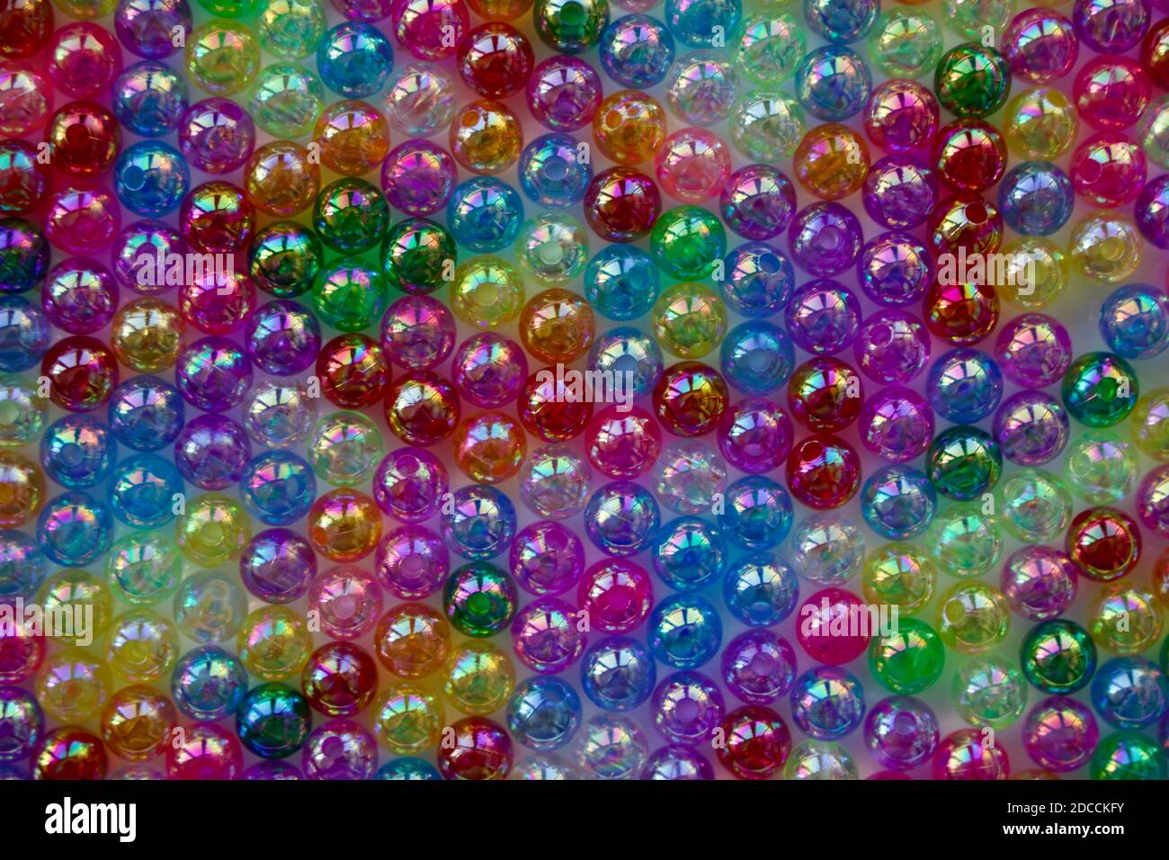Conjunto de perlas transparentes, brillantes y de muchos colores que parecen burbujas de jabón. Cuentas de semillas para usar en collares y pulseras. Foto de stock