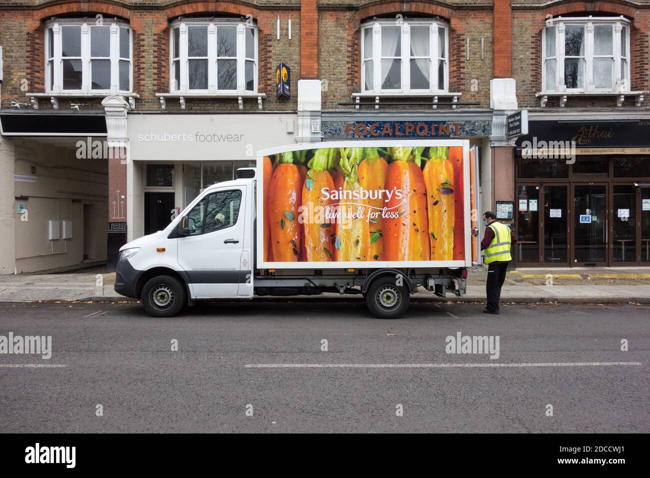 Un Sainsbury's comer bien para menos conductor de entrega en casa y.. Van en una calle de Londres Foto de stock