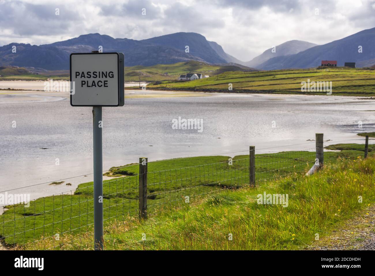 Hermoso paisaje escocés de paso signo en frente de la playa de Uig con colinas y valles en la distancia. Foto de stock