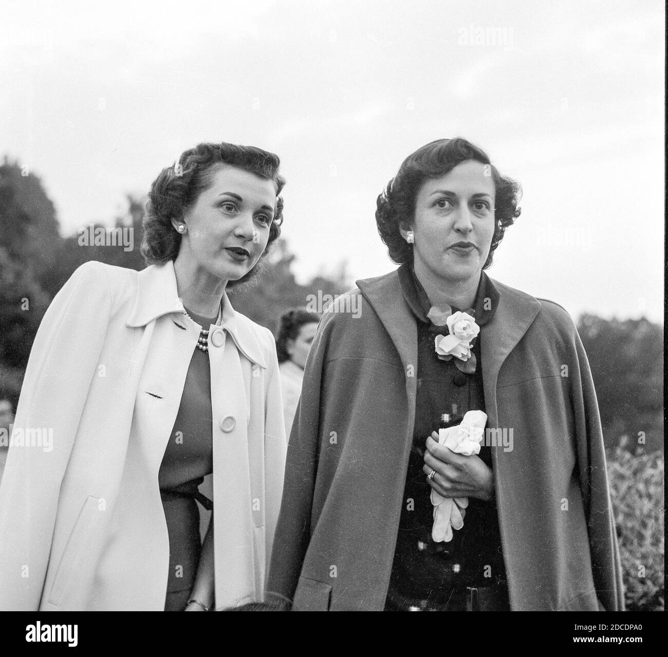 Dos mujeres morenette atractivas visitando, 1952, EE.UU. Foto de stock