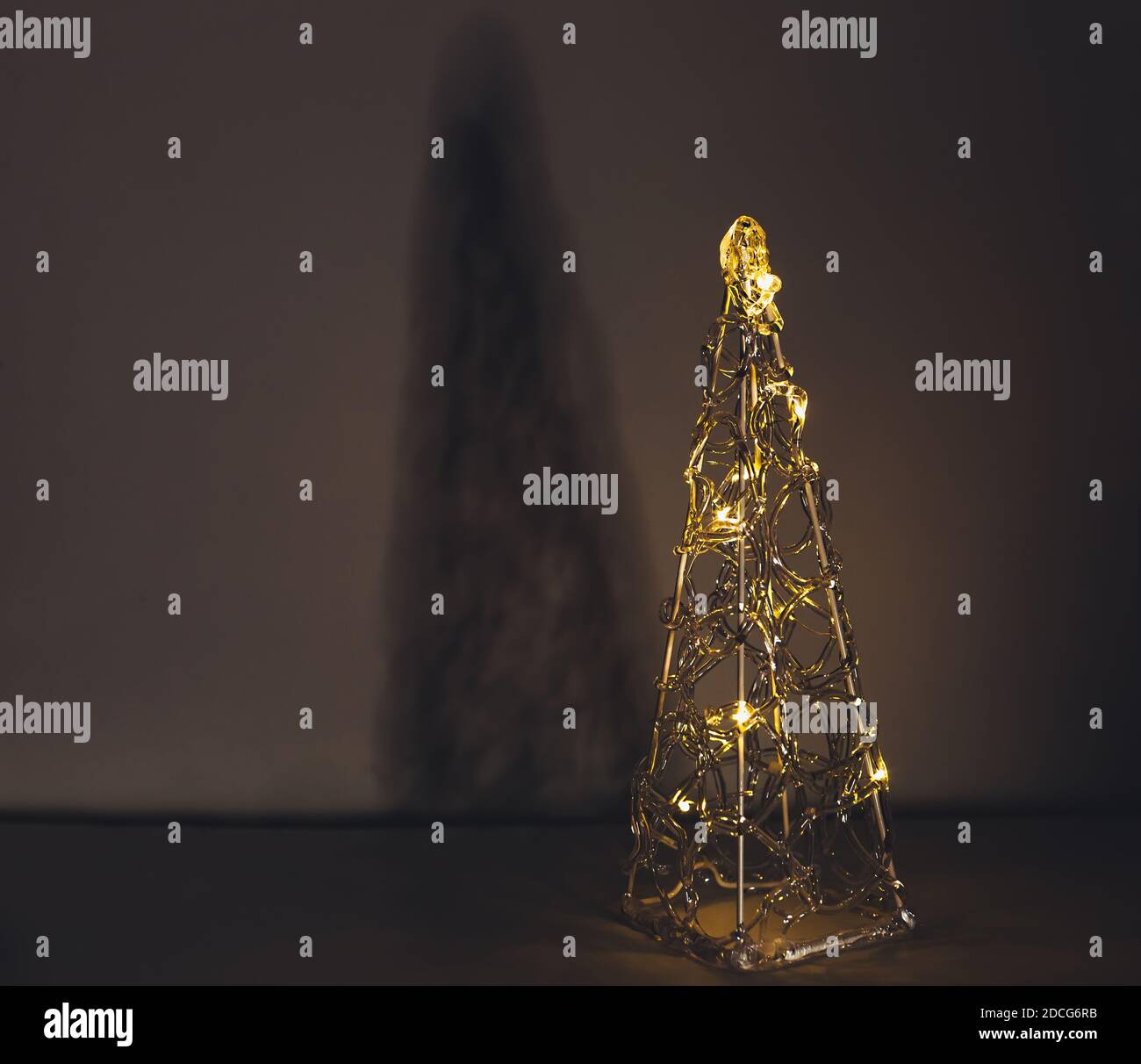 Árbol de Navidad eléctrico minimalista de plástico transparente brillante  en la oscuridad con luces amarillas cálidas, vacaciones de invierno,  tarjeta postal de año nuevo Fotografía de stock - Alamy