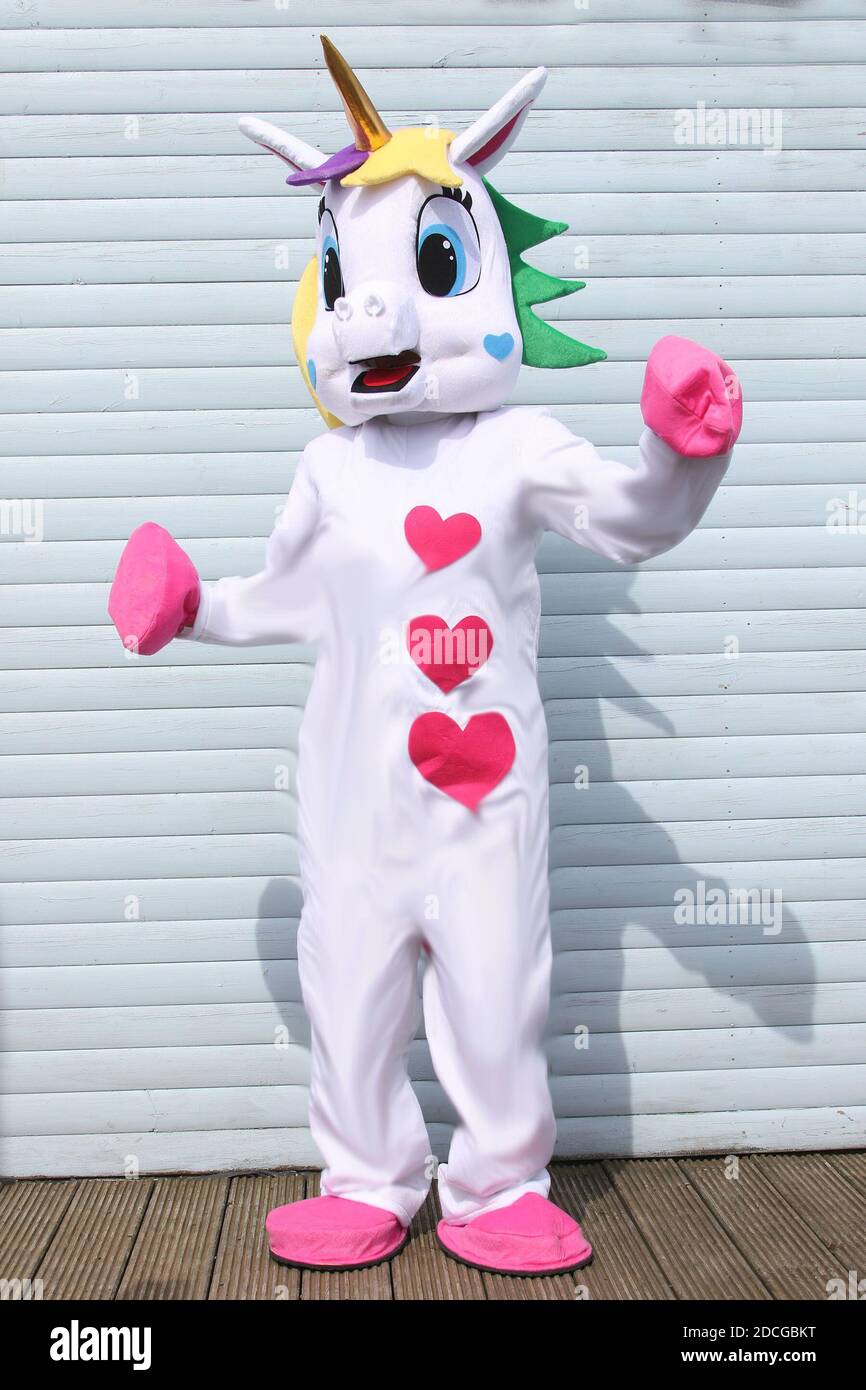 Disfraces personajes de disfraces. Una mujer con un traje gigante de  Unicornio rosa y blanco golpea la puerta de una casa Fotografía de stock -  Alamy