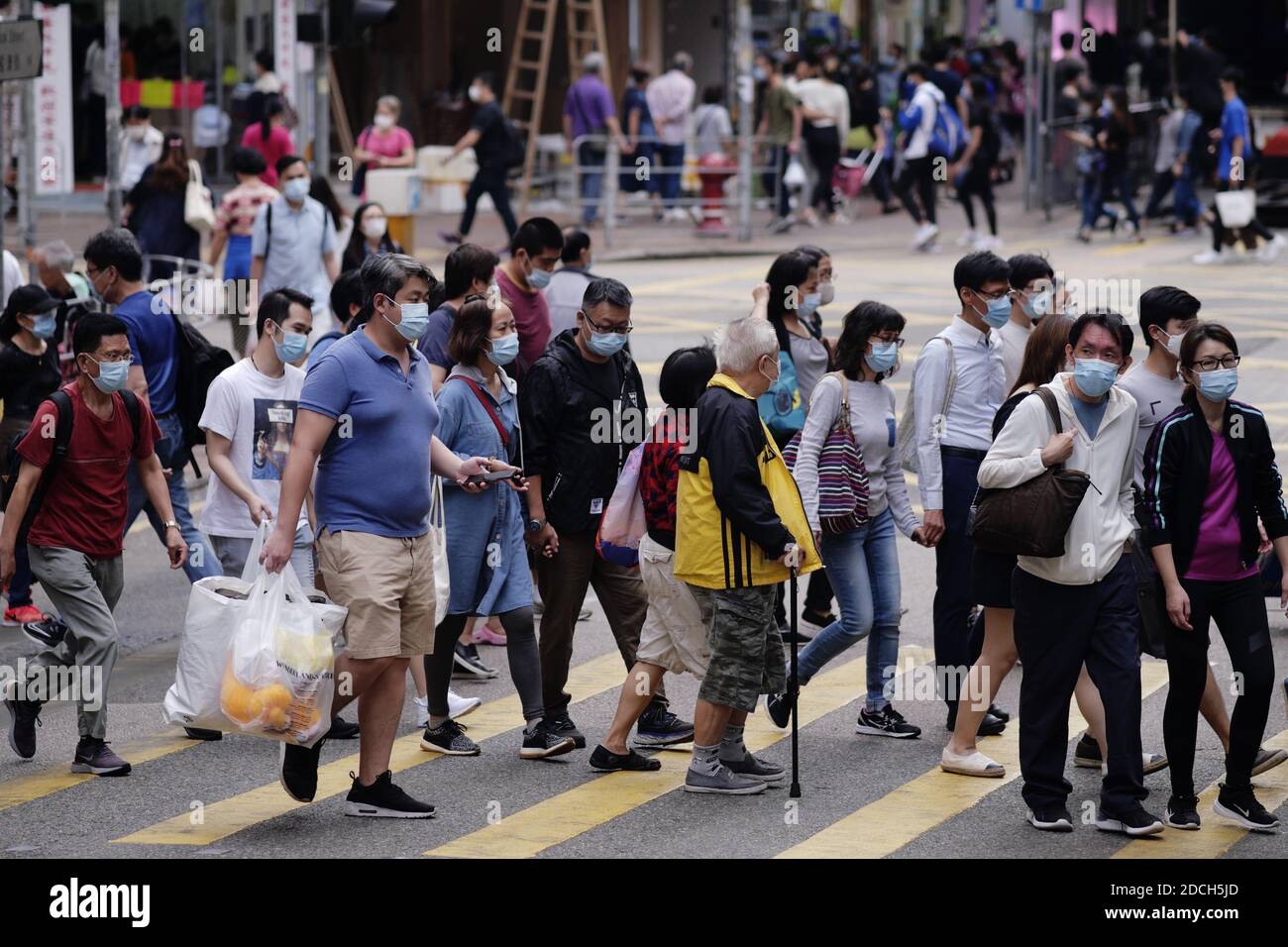 Hong Kong, China. 21 de noviembre de 2020. Los peatones que usan máscaras faciales caminan por una calle en Hung Hom, Hong Kong, China del sur, 21 de noviembre de 2020. PARA IR CON "las infecciones diarias de Hong Kong COVID-19 alcanzaron un máximo de 3 meses" crédito: Wang Shen/Xinhua/Alamy Live News Foto de stock