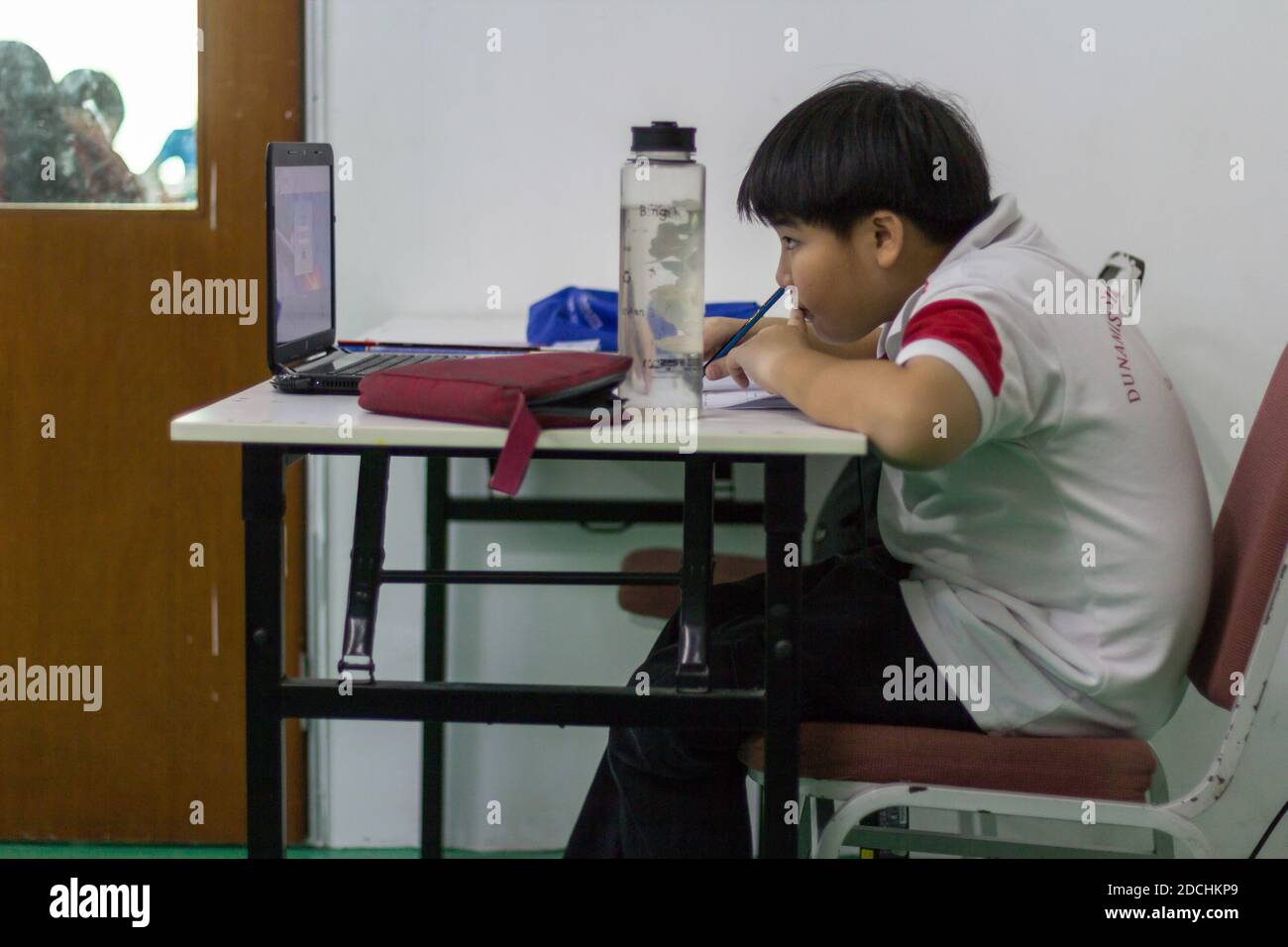 Un niño escolar se enfoca en estudiar. Foto de stock