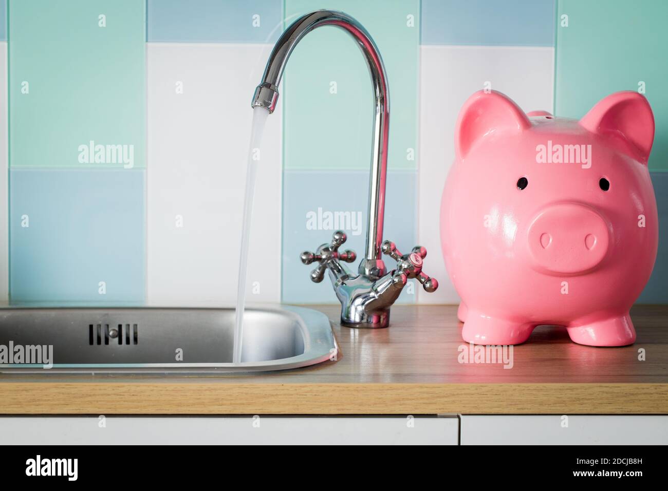 El agua corriente y un banco de pigmeos de pie junto a ella. Concepto de precio de consumo de agua Foto de stock
