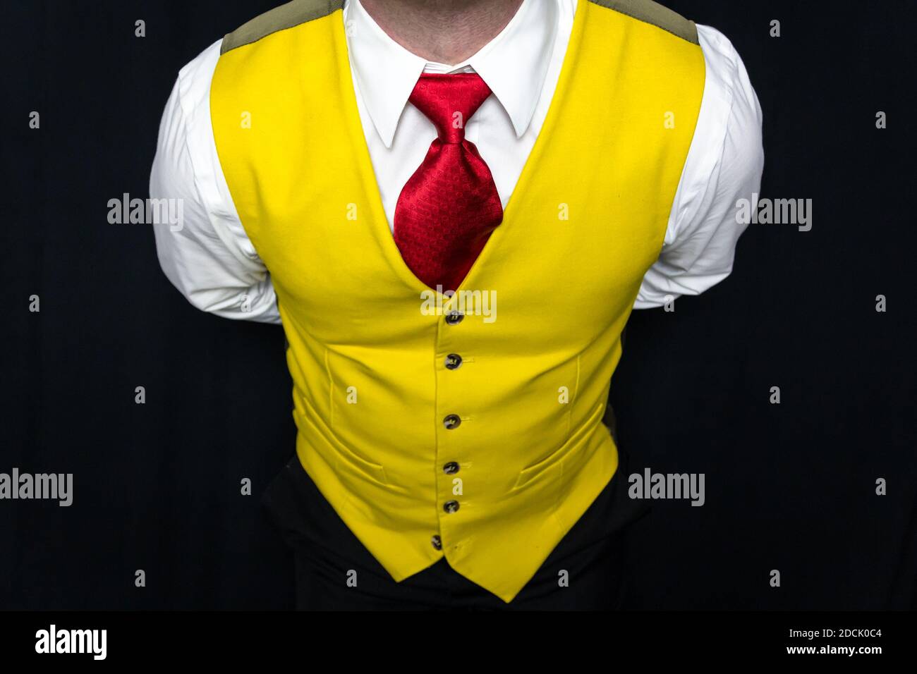 Retrato del hombre en chaleco amarillo brillante y corbata roja Con las  manos detrás de su espalda Fotografía de stock - Alamy