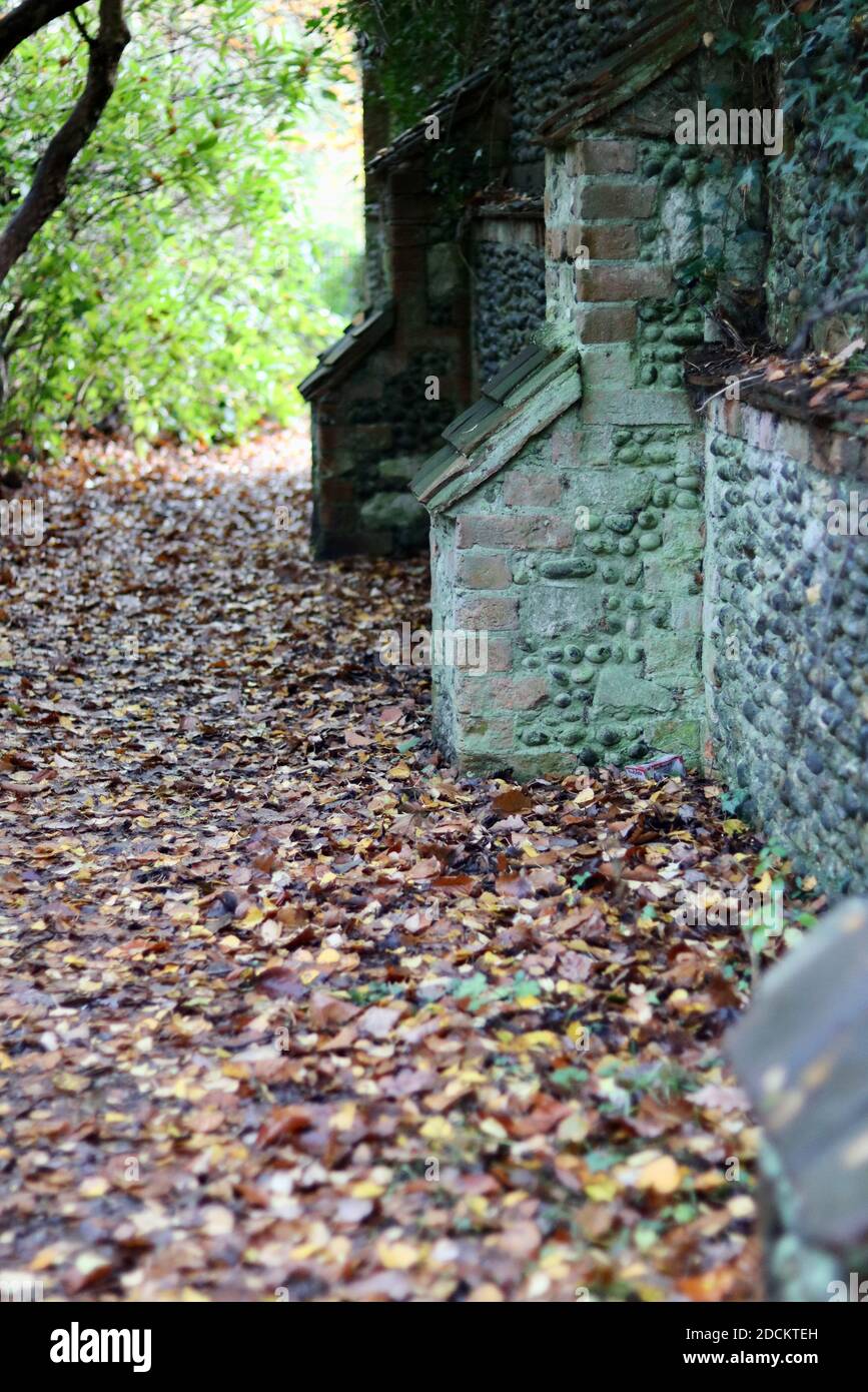 Retrato imagen de piedra vieja y pared de ladrillo con camino junto en otoño Foto de stock