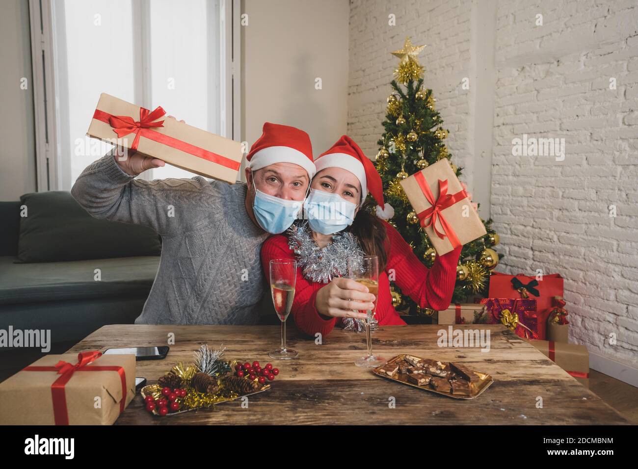 Webcam vista de feliz pareja con máscara en la videollamada celebrando  virtual Navidad y año nuevo fiesta en casa en el cierre. COVID-19 distancia  social Fotografía de stock - Alamy