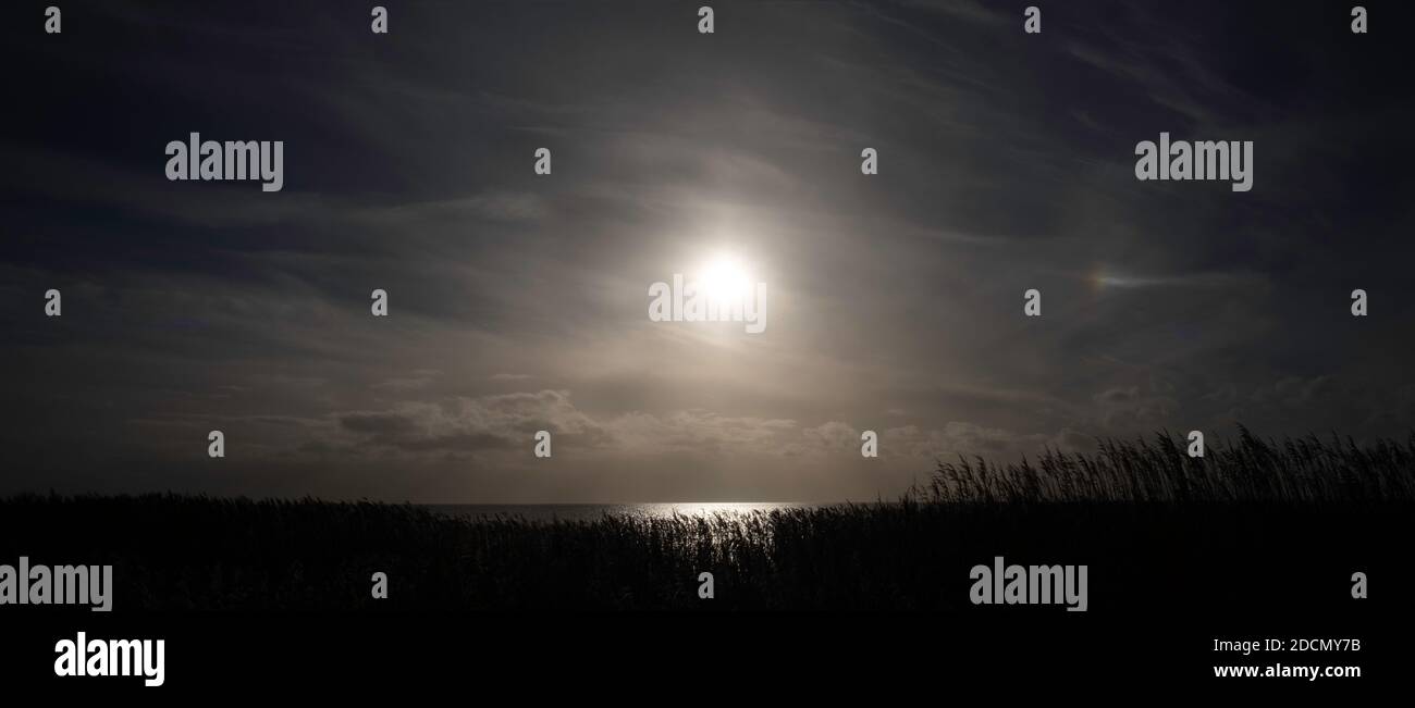 Puesta de sol sobre el Lago IJsselmeer visto desde el acantilado Mirnser cerca de la aldea Mirns en Frisia, los países Bajos en invierno. Imagen panorámica Foto de stock