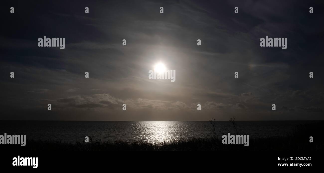 Puesta de sol sobre el Lago IJsselmeer visto desde el acantilado Mirnser cerca de la aldea Mirns en Frisia, los países Bajos en invierno. Imagen panorámica Foto de stock