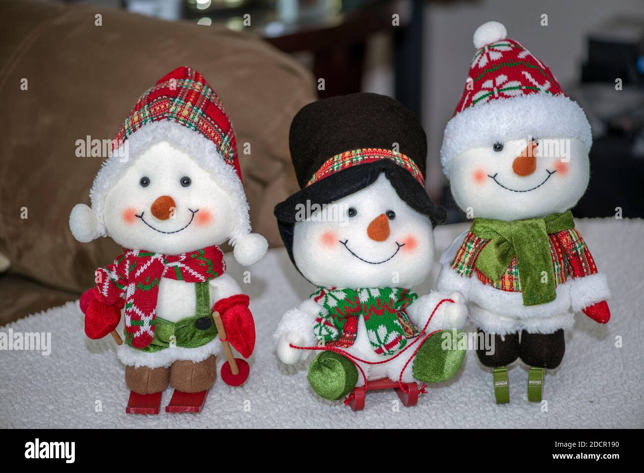 Decoración de Navidad. Tres pequeños muñecos de nieve decoran una pequeña  mesa de café Fotografía de stock - Alamy