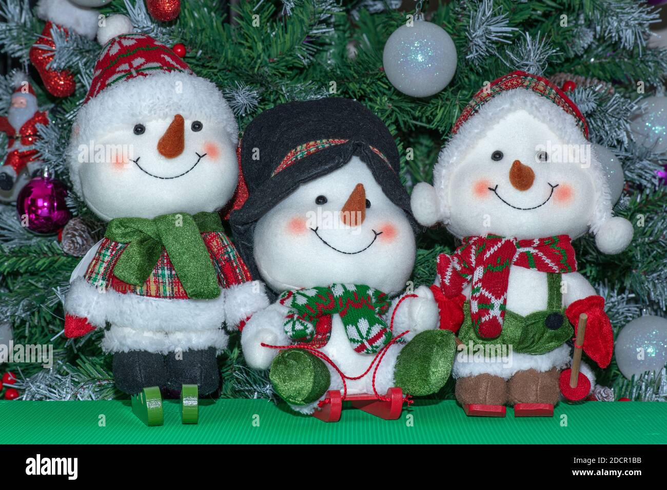 Decoración de Navidad. Tres pequeños muñecos de nieve delante de un árbol  de Navidad Fotografía de stock - Alamy