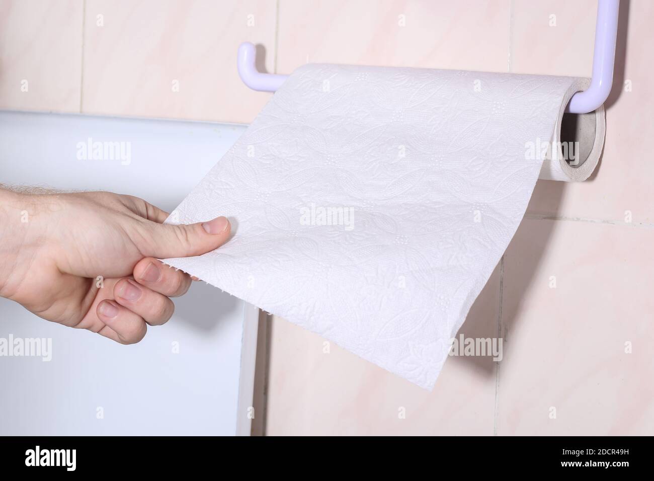 El hombre rasga una hoja de papel de té toalla para secar sus manos  Fotografía de stock - Alamy