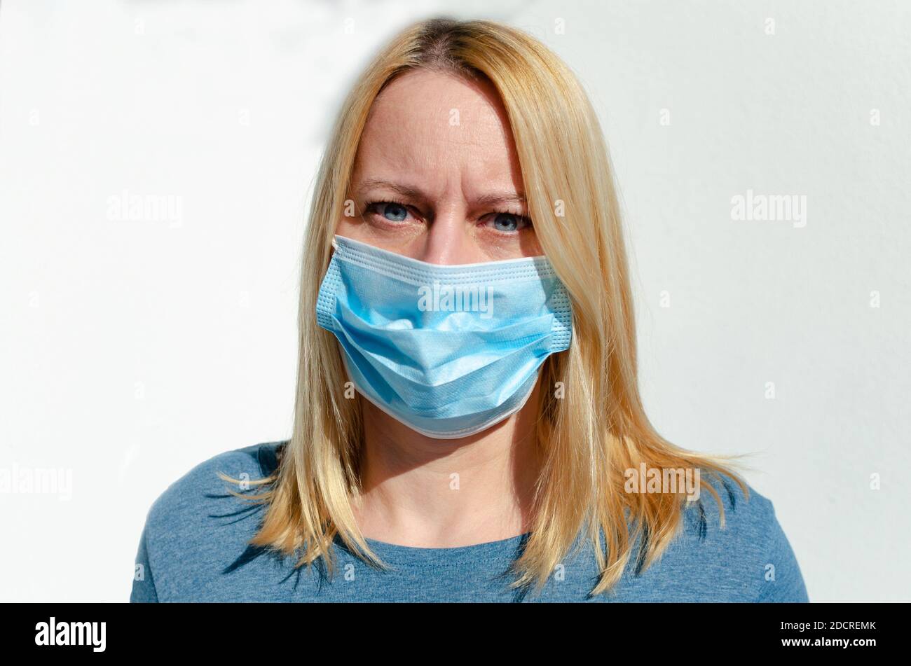 Retrato de una mujer de mediana edad en una máscara protectora en la cara aquí durante la pandemia de covid-19 Foto de stock