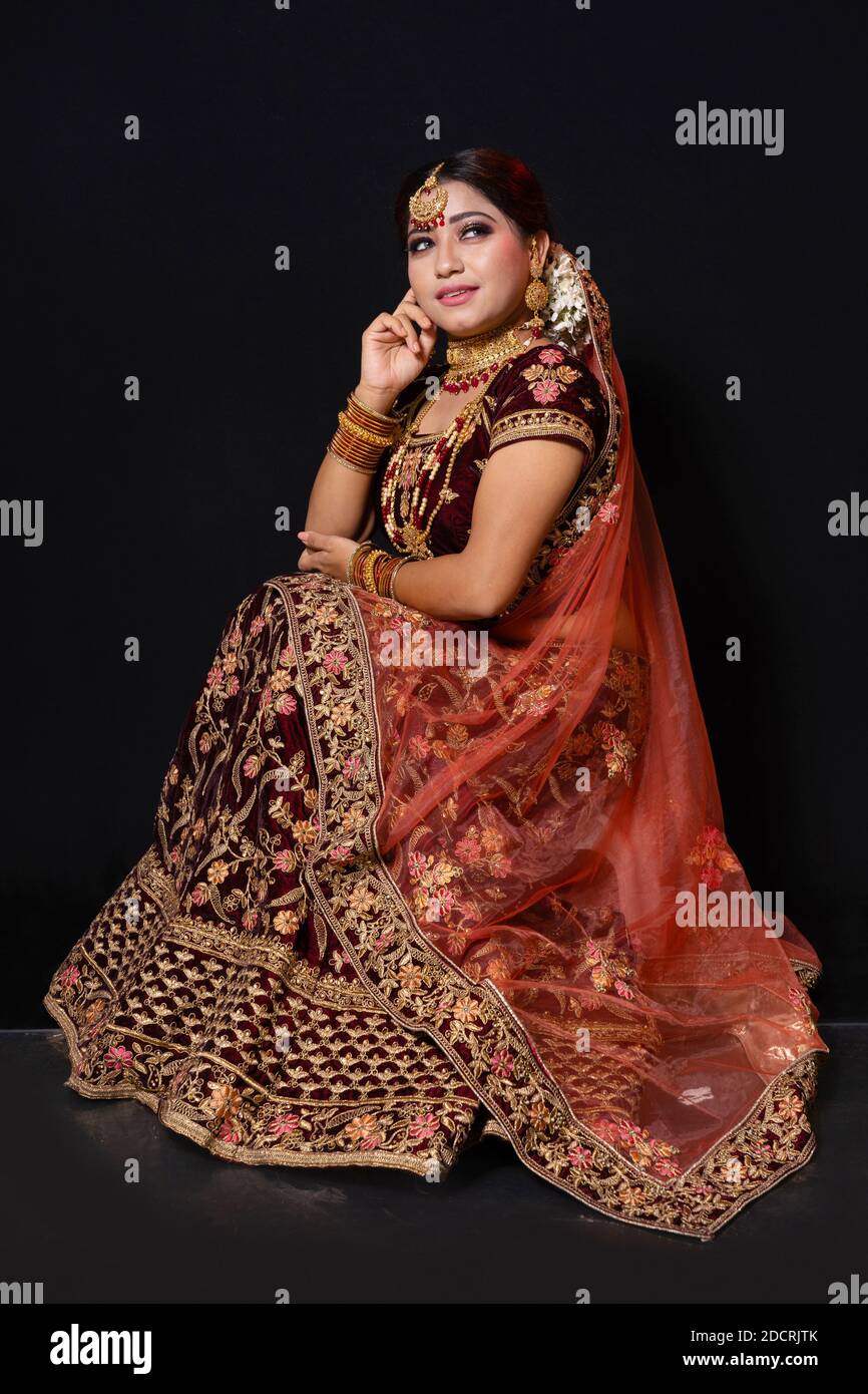 Joven modelo femenino atractivo vestido con traje tradicional indio lehenga  choli con joyería de estilo Kundan. Disparo completo. Fondo negro  Fotografía de stock - Alamy