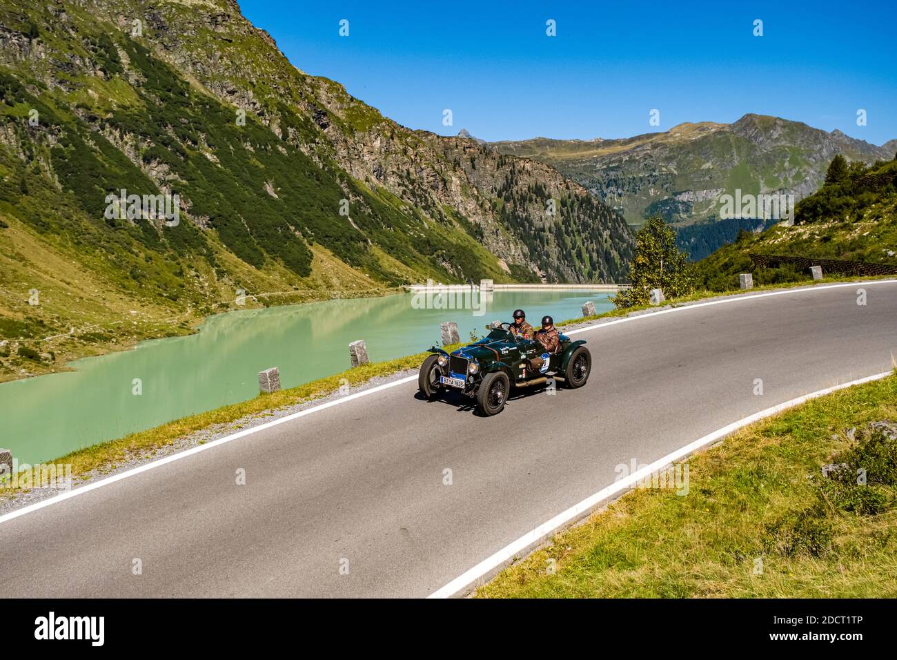 Un coche antiguo ALVIS FIREBIRD ESPECIAL pasando por un lago en Silvretta Hochalpenstrasse durante el Arlberg Classic Car Rally. Foto de stock