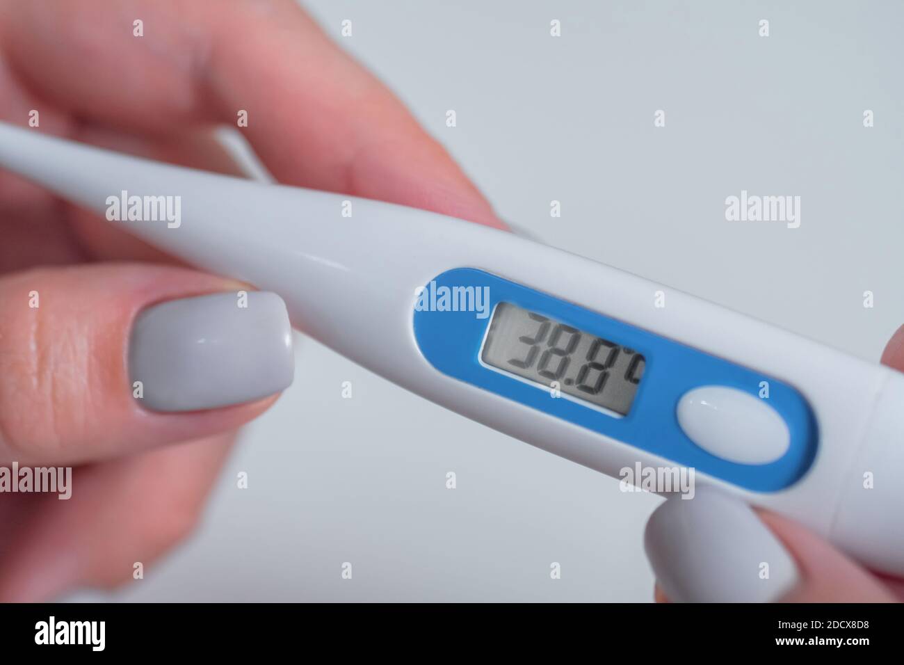 Mujer sosteniendo termómetro médico digital con alta temperatura - cerca arriba Foto de stock