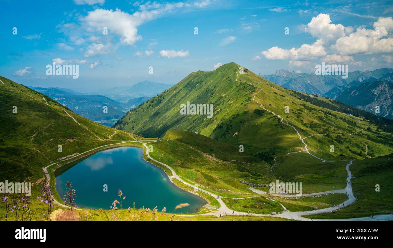 Austria, Kleinwalsertal, pequeño lago de montaña que refleja las nubes y el cielo en el pico de la montaña kanzelwand en los alpes montañas naturaleza paisaje Foto de stock