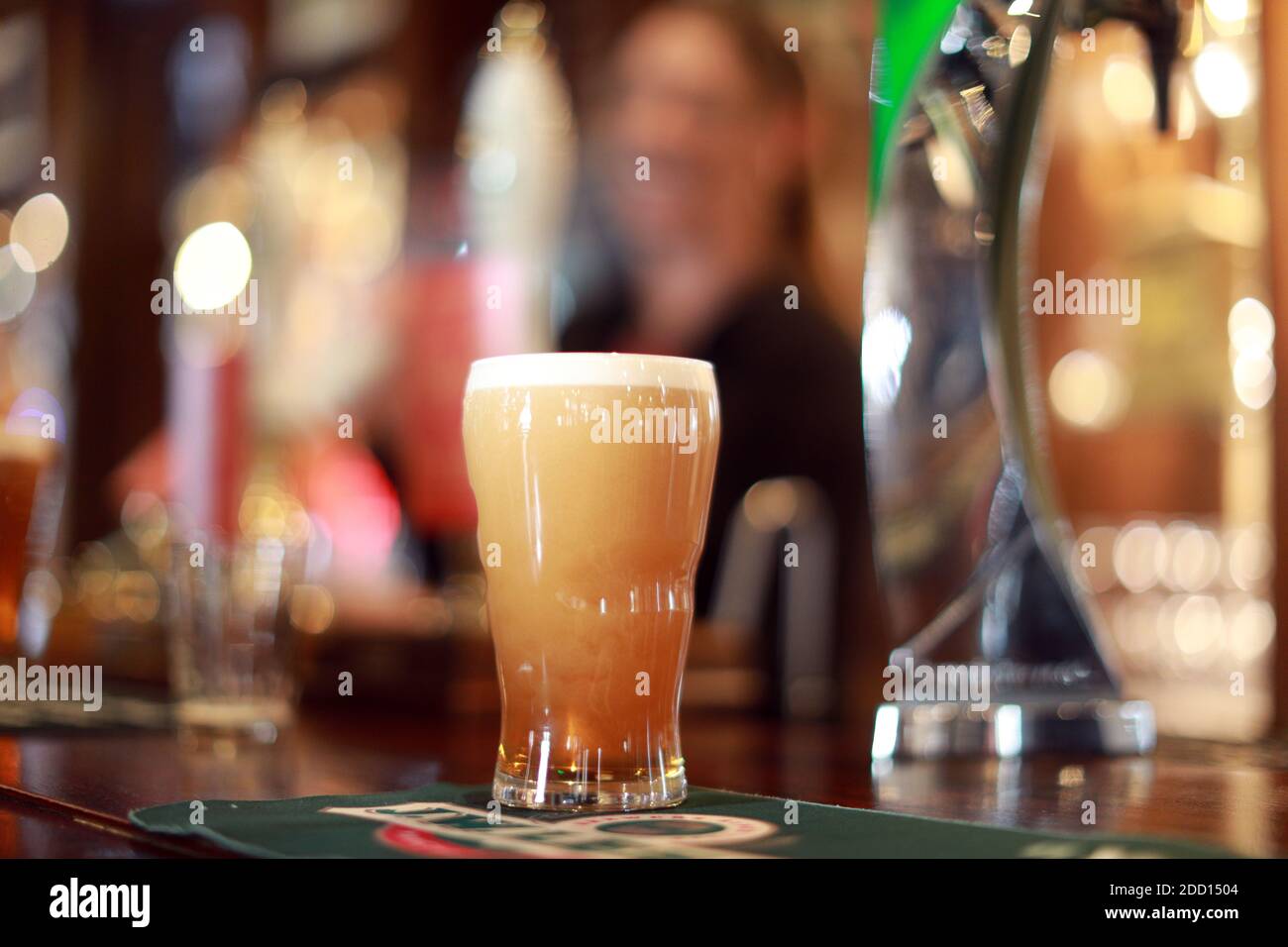 Una pinta fresca de cerveza verdadera en un pub. Cerveza de barril en una pinta de vidrio Foto de stock