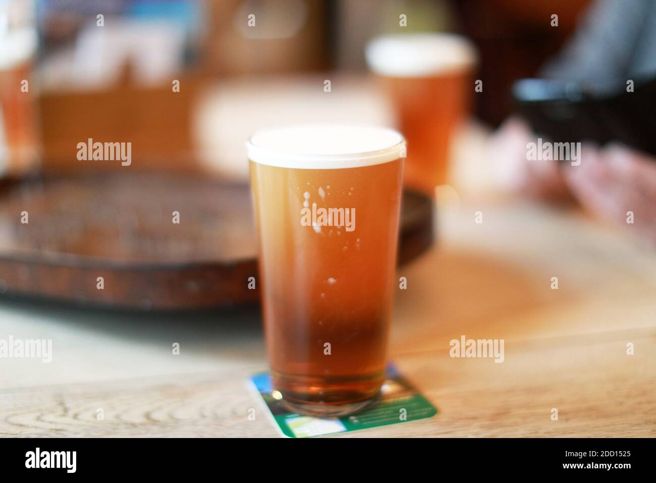Una pinta fresca de cerveza verdadera en un pub. Cerveza de barril en una pinta de vidrio Foto de stock