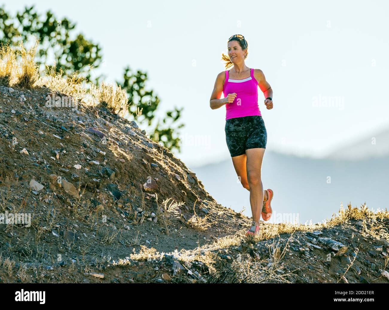 Mujer atractiva de mediana edad que corre por senderos de montaña; salida; Colorado; Estados Unidos Foto de stock