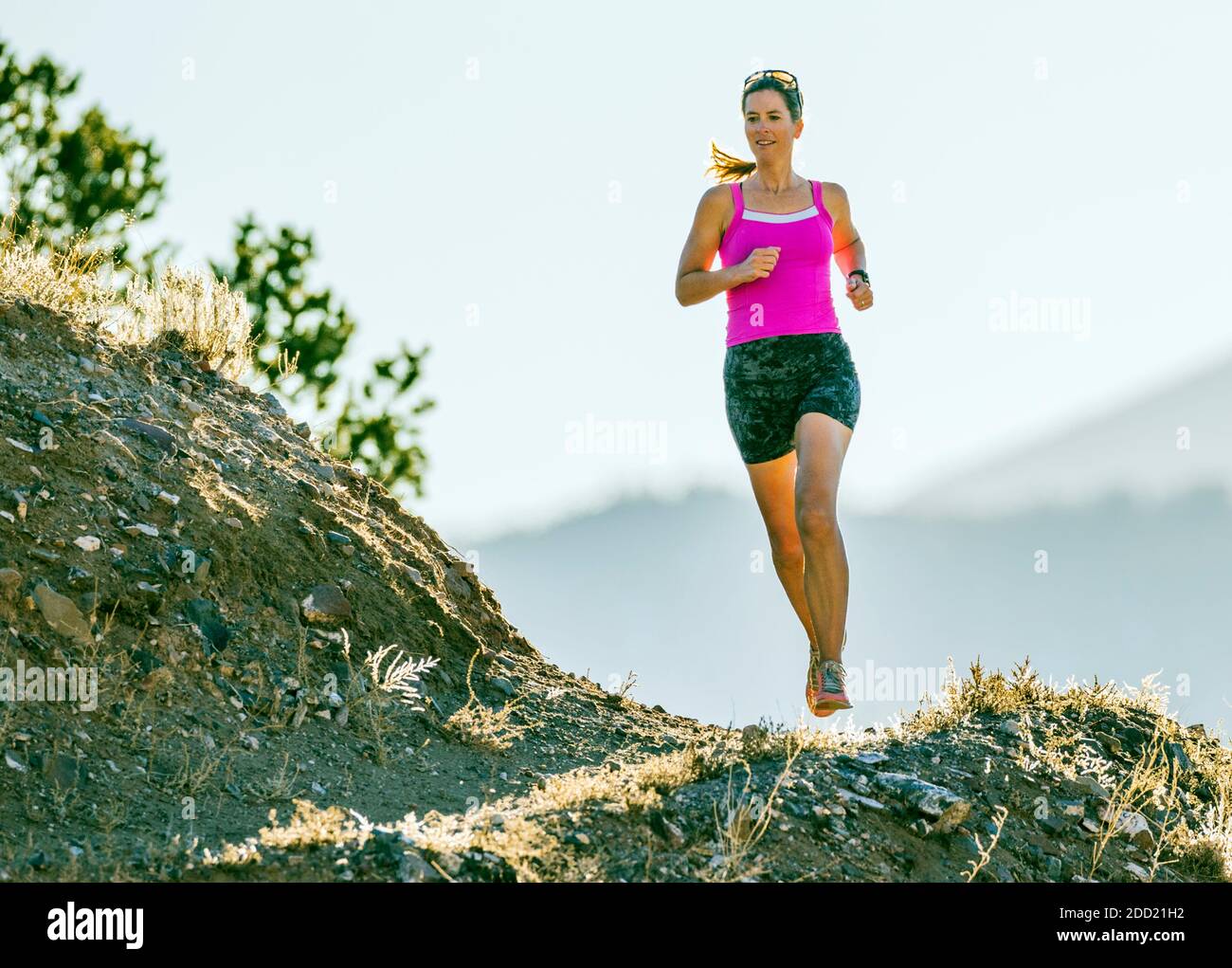 Mujer atractiva de mediana edad que corre por senderos de montaña; salida; Colorado; Estados Unidos Foto de stock