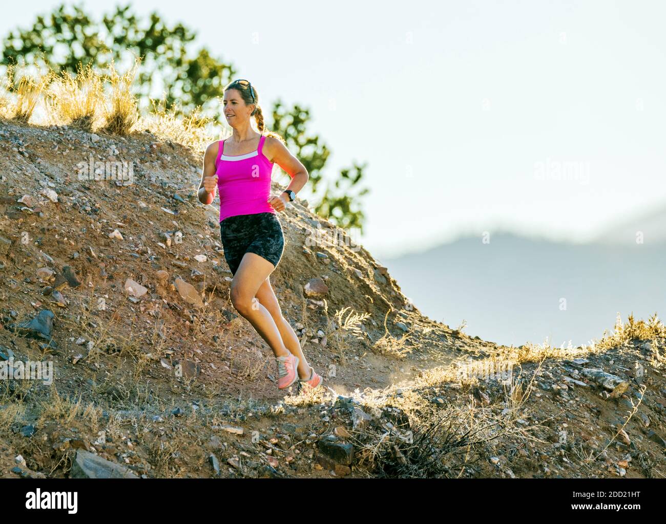 Mujer atractiva de mediana edad que corre por senderos de montaña; salida; Colorado; Estados Unidos Foto de stock
