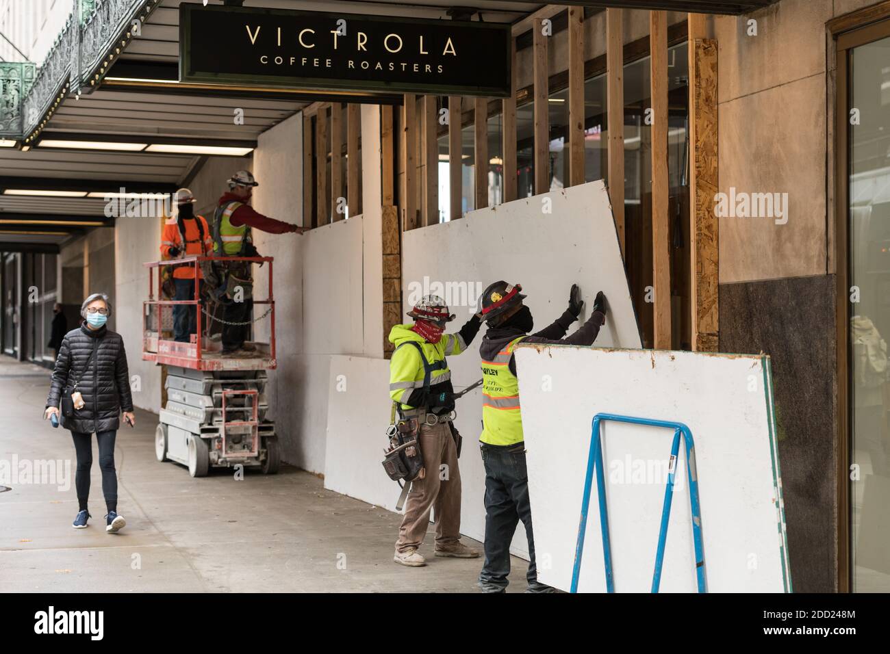 Seattle, EE.UU. 23 de noviembre de 2020. Trabajadores de medio día que se  descomponen de tablas que cubren las ventanas de Victrola Coffee en el  edificio del Amazonas Fotografía de stock - Alamy
