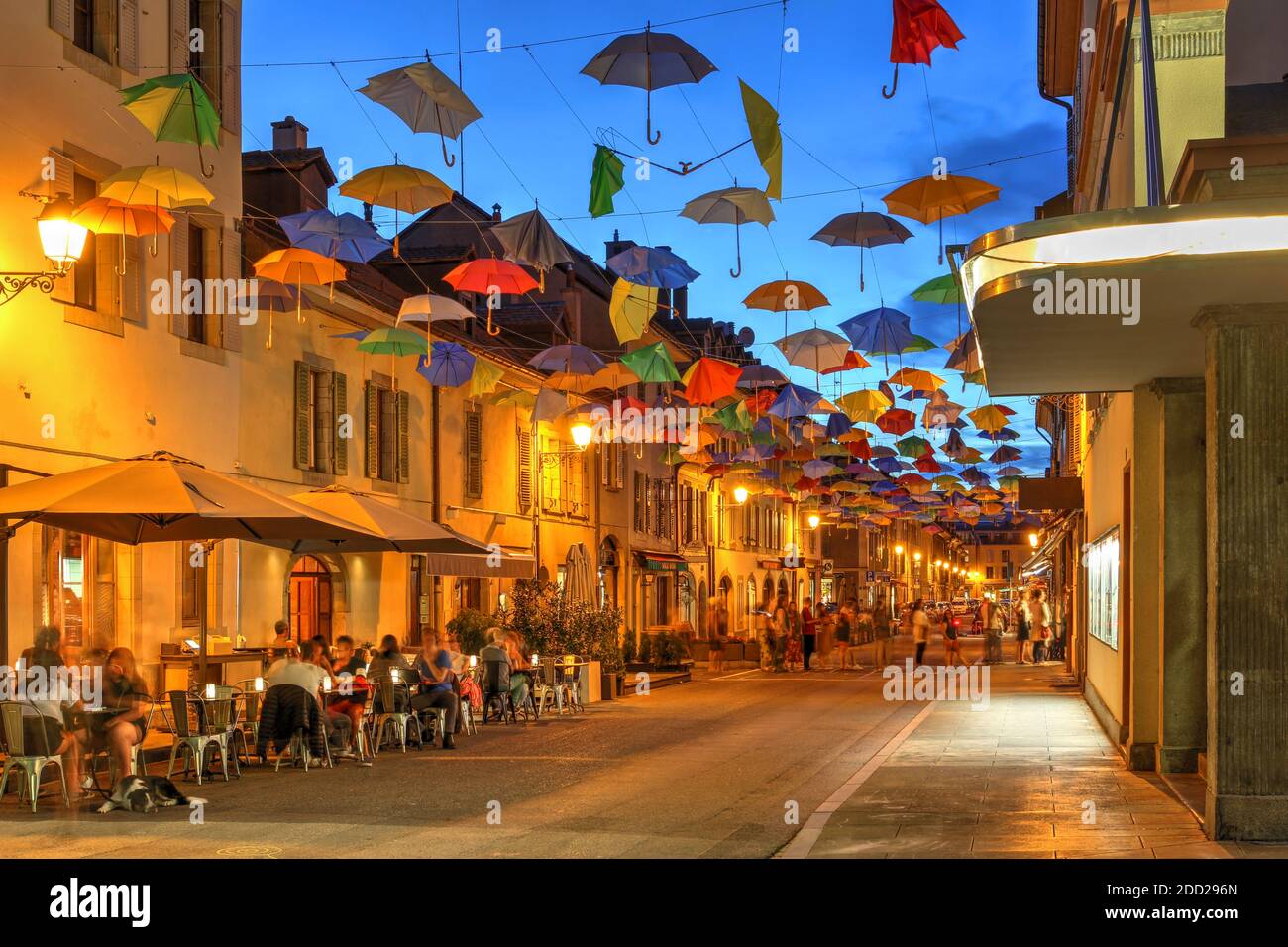 Rue de Saint Joseph en Carouge, Ginebra, Suiza cubierto por paraguas de  colores, con una línea visible de la gente a la famosa tienda de helados,  como Wel Fotografía de stock -