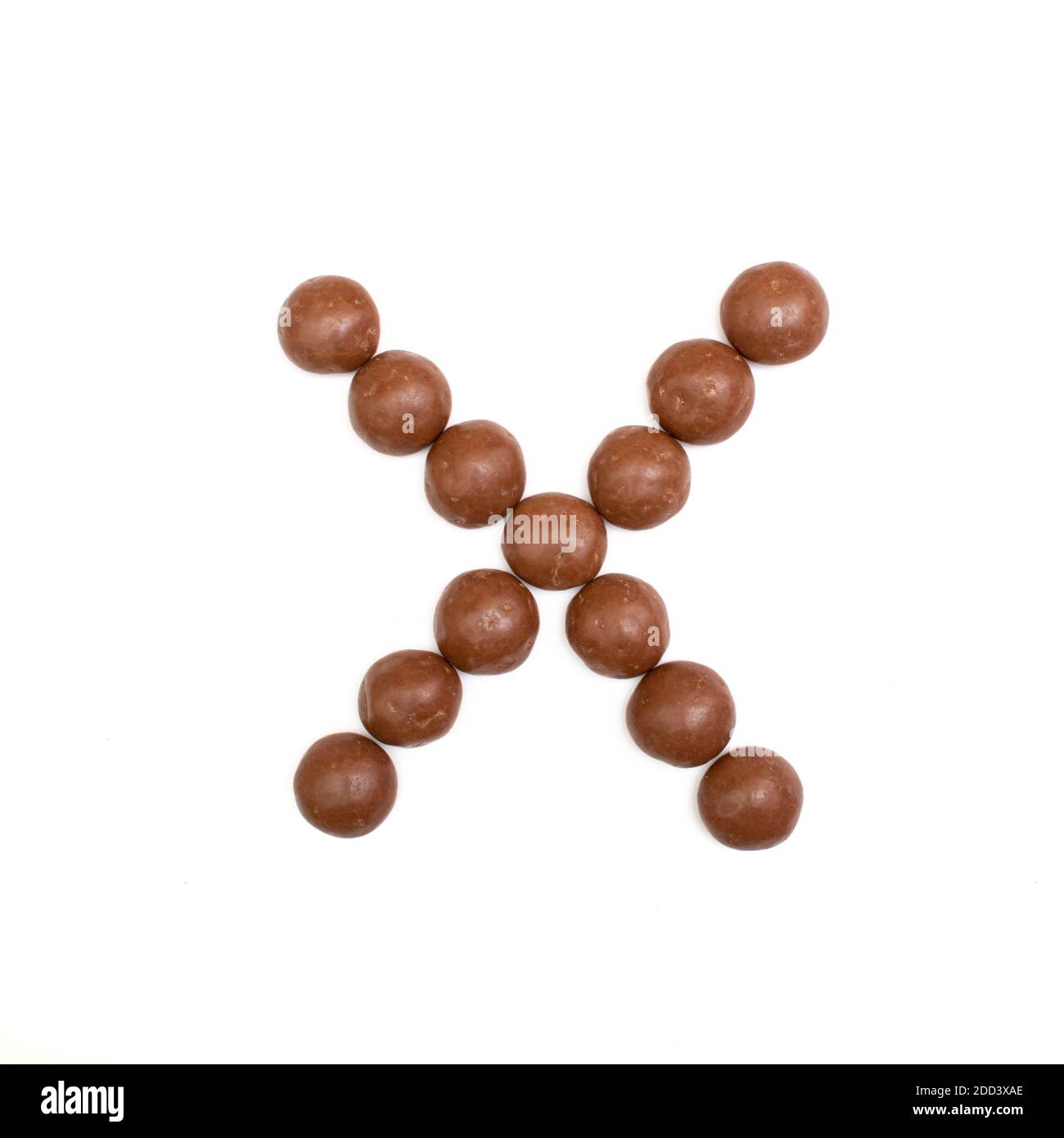 La letra 'X' escrita en chocolate marrón Pepernoten, un dulce tradicional holandés para la fiesta Sinterklaas el 5 de diciembre Foto de stock