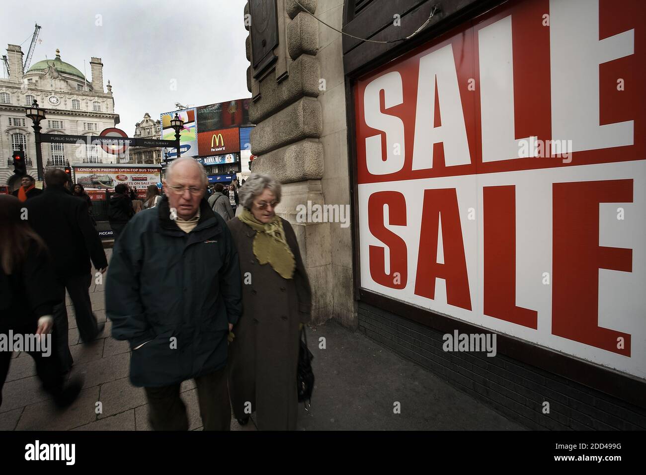 GRAN BRETAÑA / Londres / Pareja mayor caminar más allá de las señales de venta al lado de Piccadilly Circus . Foto de stock