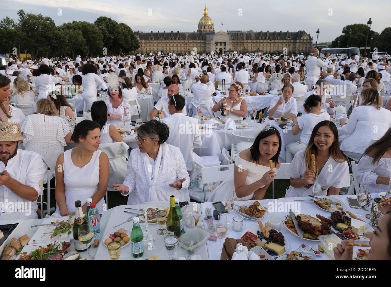 Los participantes vestidos de blanco participan en el Diner en Blanc (Cena  en Blanco) en los jardines de los Invalides, en París, los parisinos y los  extranjeros están preparando hámpers de picnic