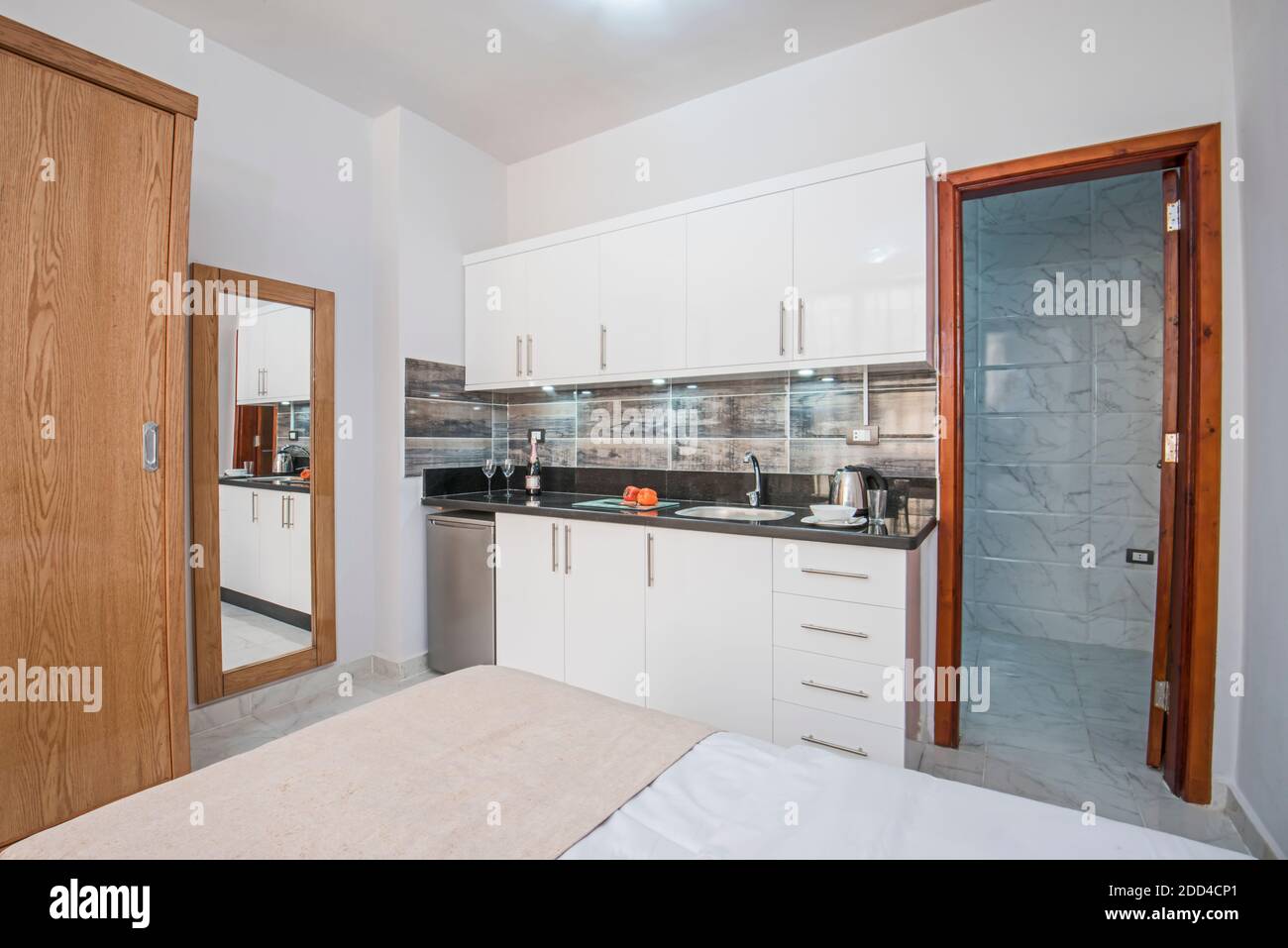 Decoración de diseño interior que muestra la cocina moderna y electrodomésticos en un lujoso salón de exposición de apartamentos de estudio Foto de stock