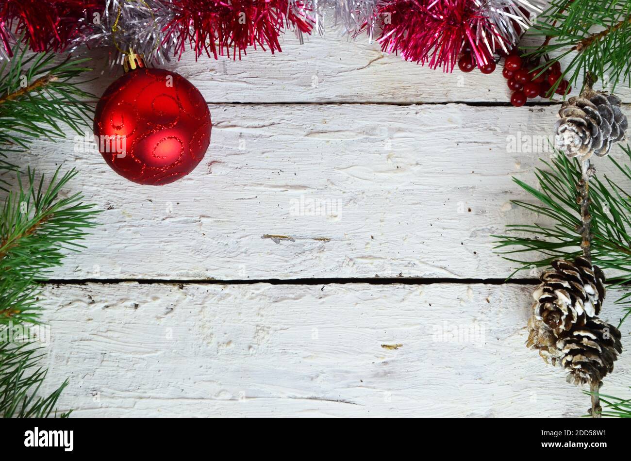 Marco de Navidad de abeto, rama de bola roja de un árbol de Navidad, un  regalo atado con una cinta roja en un fondo blanco de madera decoraciones  de Navidad. Copiar Fotografía