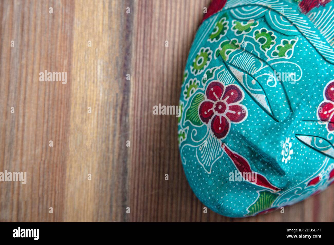 Máscara de madera tradicional decorada en Asia | Máscara pintada en Malasia sobre mesa de madera Foto de stock