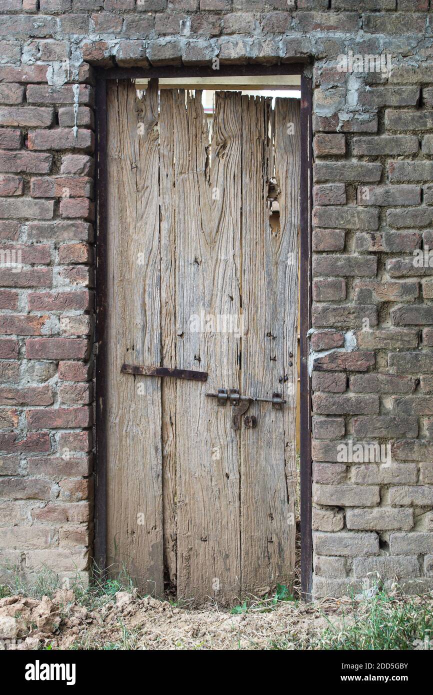 Antigua y rota puerta de madera de una casa abandonada en un bosque Foto de stock