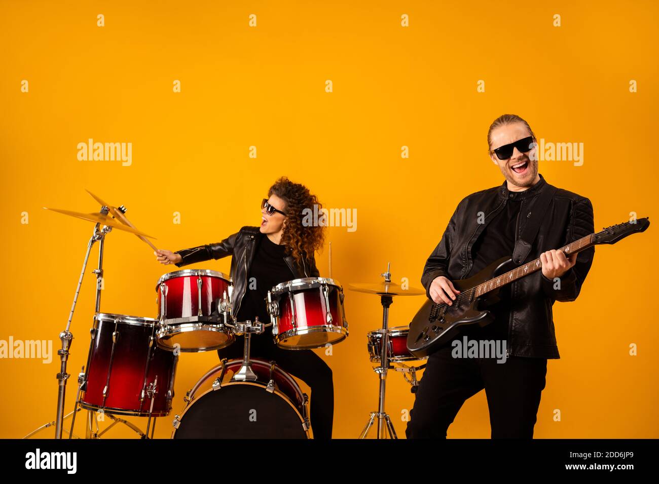 Foto del famoso grupo de rock popular tipo tocar la guitarra eléctrica  bonita chica sentarse instrumentos batería golpe discoteca concierto de  actuación hall de vestir negro Fotografía de stock - Alamy