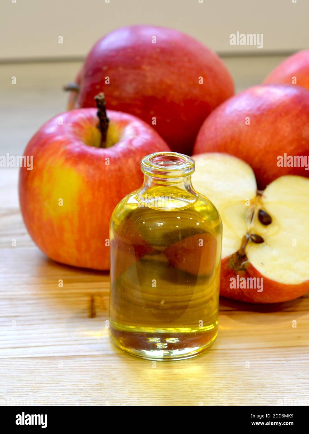 Vinagre de sidra de manzana en botella de vidrio y manzanas frescas fondo de madera Foto de stock