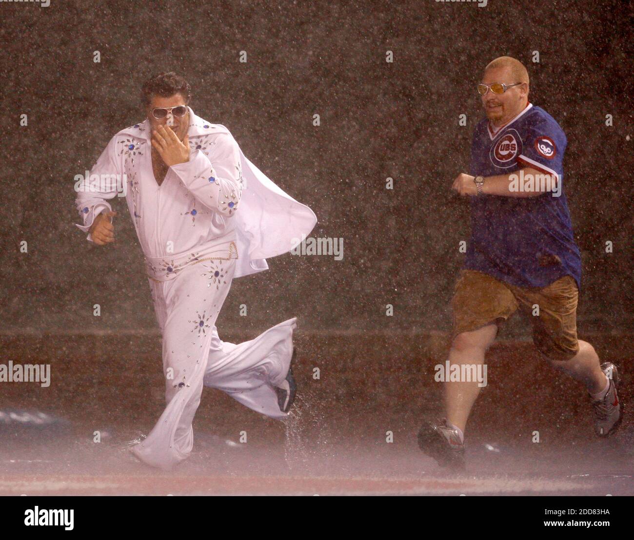 Los fans de Chicago Cubs son arrestados después de deslizarse en el tarp durante un retraso de lluvia en el juego de los Cubs contra los Astros de Houston en Wrigley Field en Chicago, Illinois, el lunes 4 de agosto de 2008. Foto de Nuccio DiNuzzo/Chicago Tribune/MCT/Cameleon/ABACAPRESS.COM Foto de stock