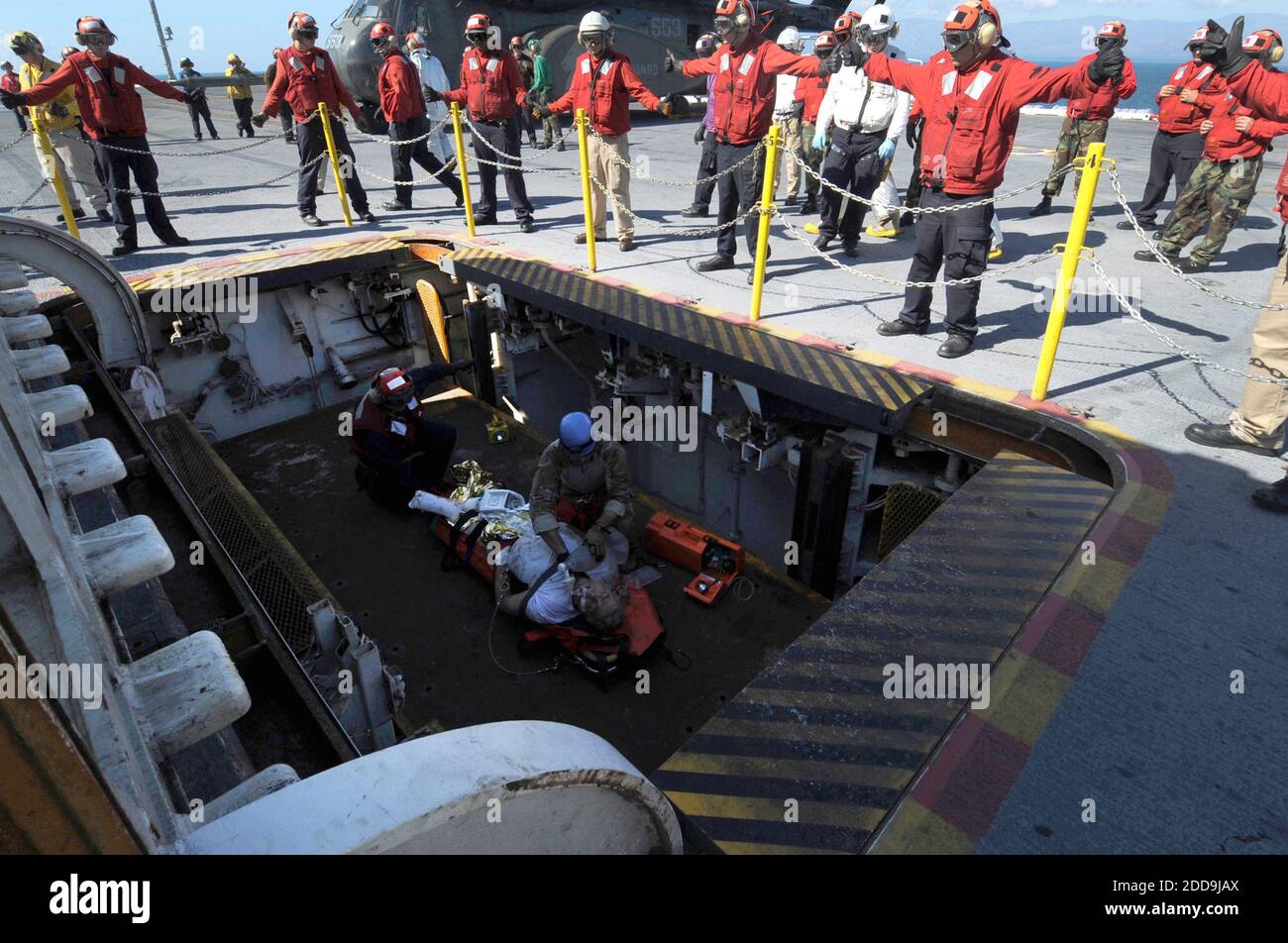 NO HAY PELÍCULA, NO HAY VIDEO, NO hay televisión, NO HAY DOCUMENTAL - los marineros de la Marina de los Estados Unidos entregan a un ciudadano estadounidense herido a USS Carl Vinson el viernes, 15 de enero de 2010. El departamento de Servicios de Salud trasladó al hombre a uno de los ascensores de la cubierta para el traslado a la instalación médica del barco. Carl Vinson y Carrier Air Wing 17 están llevando a cabo operaciones humanitarias y de socorro en casos de desastre en Haití en respuesta al desastre del terremoto del 12 de enero de 2010. Foto de Adrian White/Noticias de la Marina de EE.UU. Foto/MCT/ABACAPRESS.COM Foto de stock