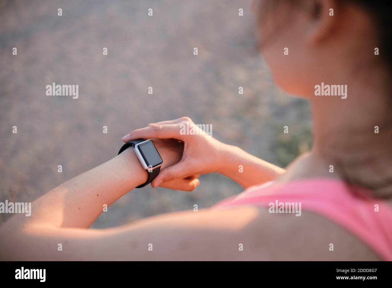 Ajuste a un joven atleta comprobando a tome en un reloj inteligente Foto de stock