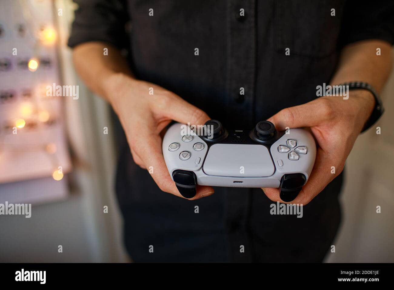 PlayStation 5 Sony revela la consola PS5 y los juegos. Controlador Dualsense. Mujer sosteniendo el joystick Foto de stock