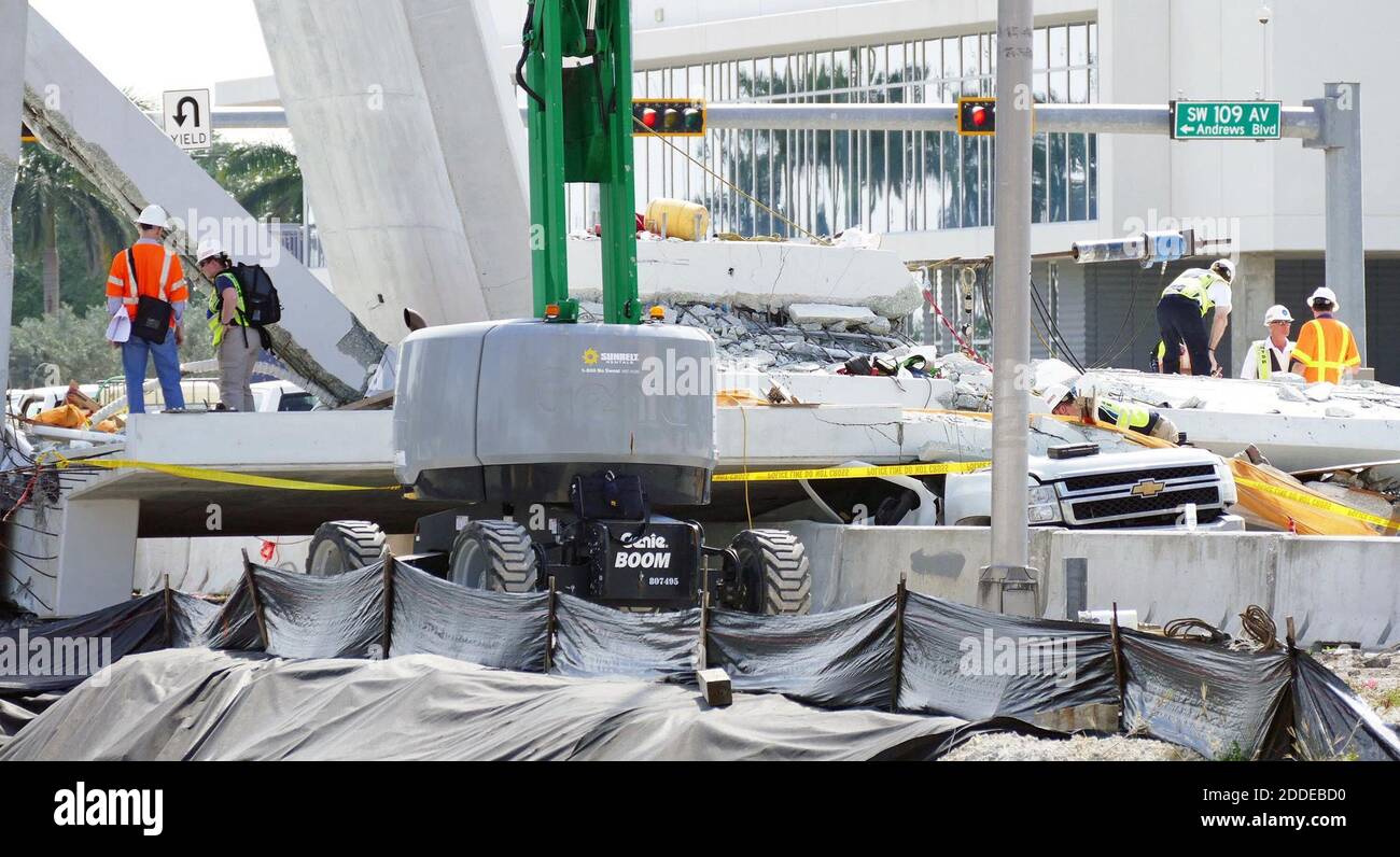 NO HAY PELÍCULA, NO HAY VÍDEO, NO hay televisión, NO HAY DOCUMENTAL - los inspectores se estremecen alrededor del extremo norte del puente peatonal de la Universidad Internacional de Florida, donde se encontraron grietas antes de que el puente colapsara, el domingo, 18 de marzo de 2018. La sección sigue siendo objeto de una inspección más estrecha. A la derecha, el último vehículo que queda todavía está bajo los escombros de hormigón. Foto de C.M. Guerrero/Miami Herald/TNS/ABACAPRESS.COM Foto de stock