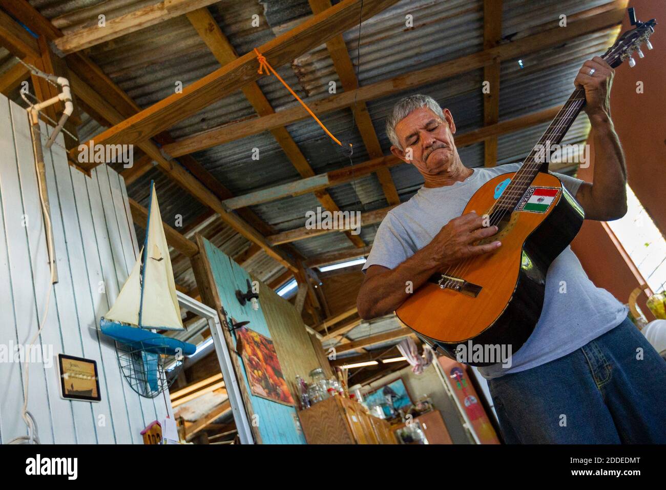 NO HAY PELÍCULA, NO HAY VIDEO, NO hay televisión, NO HAY DOCUMENTAL -  Guillermo José Torres, de 60 años, toca su guitarra en su casa de playa  dañada por el huracán en
