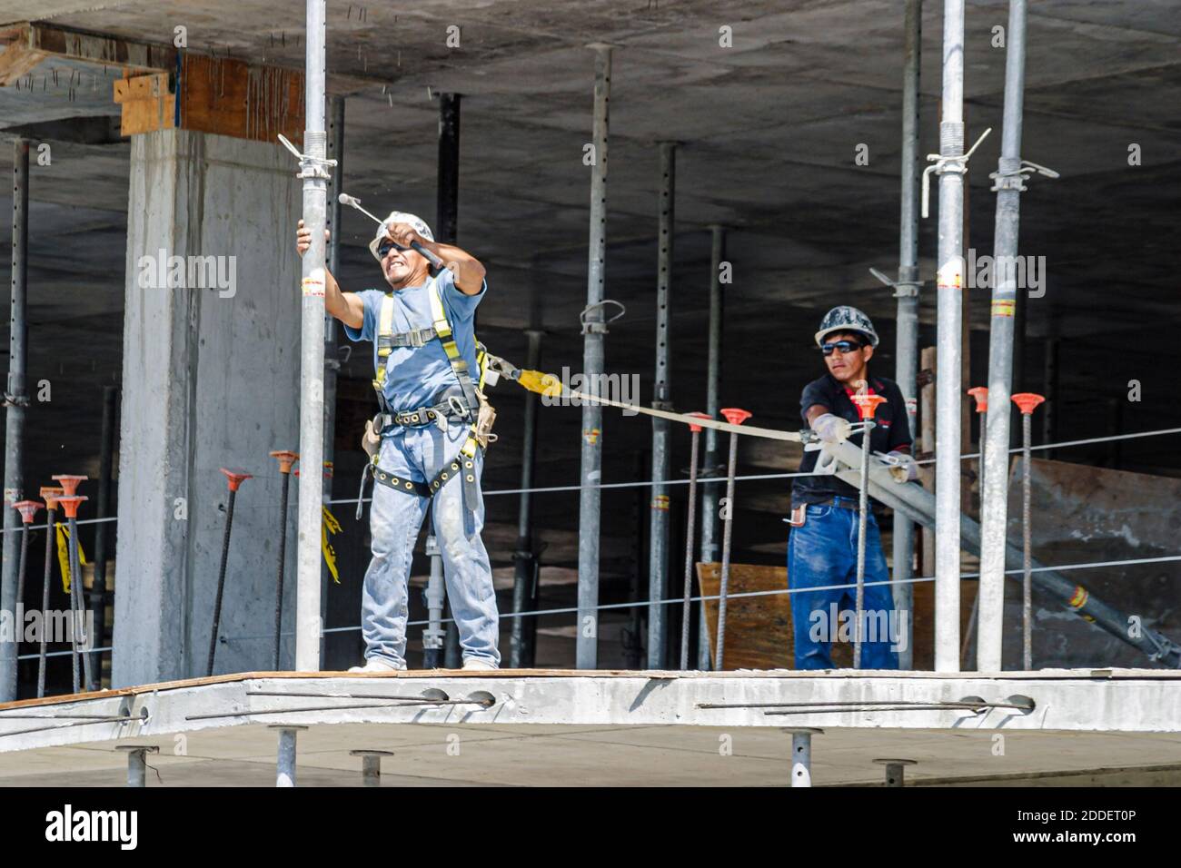 Miami Beach Florida, Dade Boulevard, nuevo trabajador de construcción en construcción que lleva casco, línea de cinturón de seguridad atada trabajo peligroso, Foto de stock