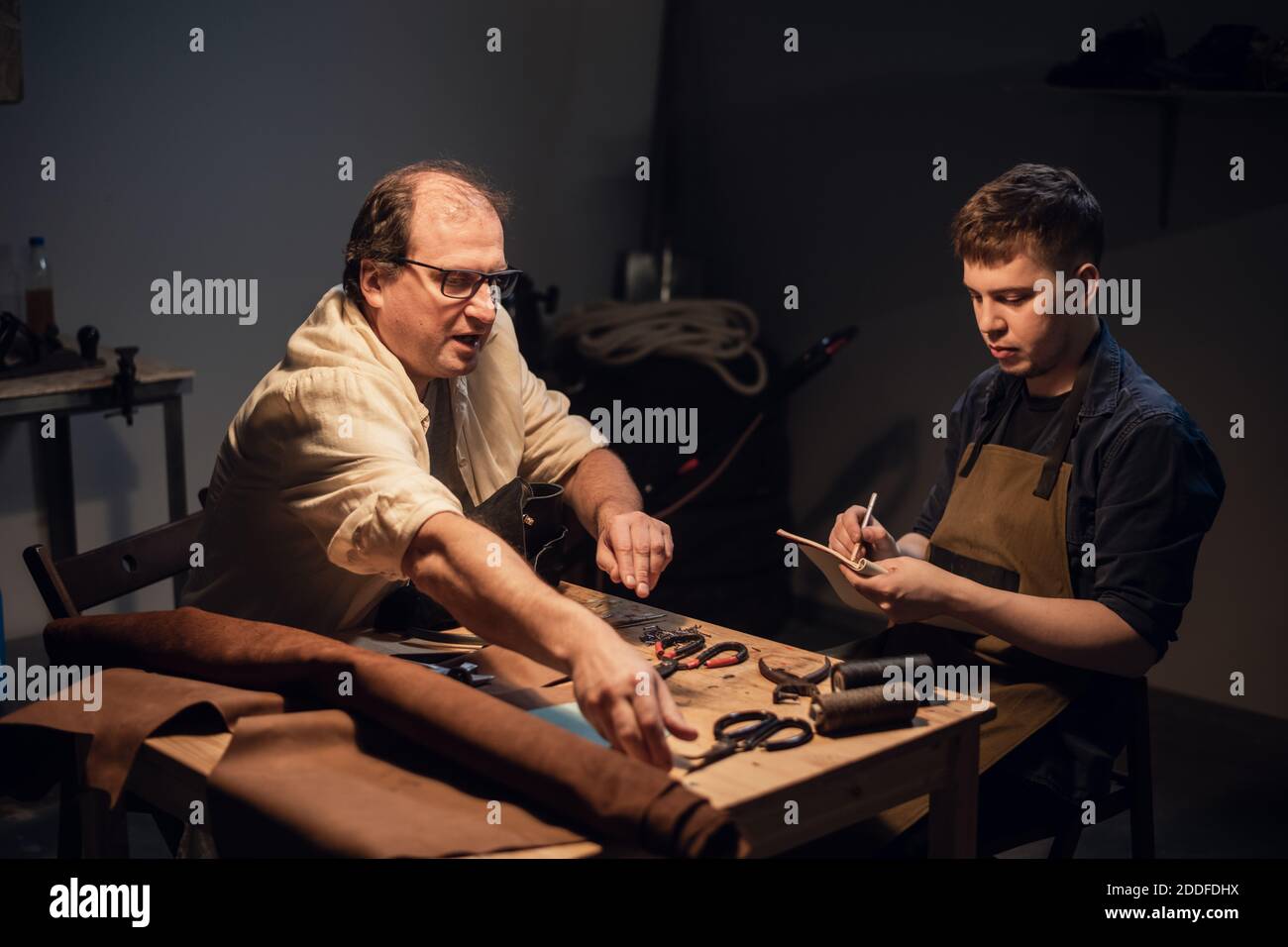 un padre-zapatero pasa a su hijo la experiencia de fabricación de zapatos a  mano en su taller Fotografía de stock - Alamy