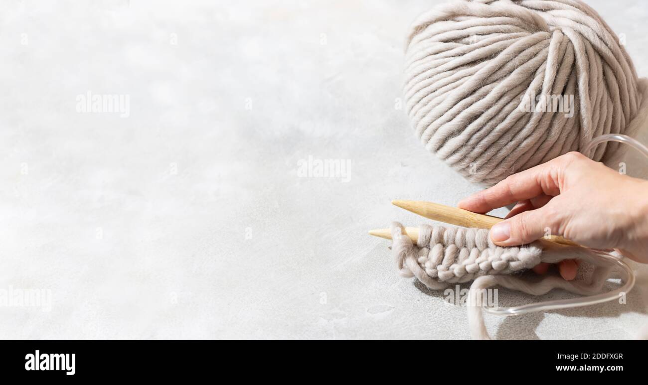 Las manos femeninas tejen con lana gris. Primer plano de las agujas de  tejer de madera. Concepto de cero residuos. Tejer a mano. Espacio de copia  Fotografía de stock - Alamy