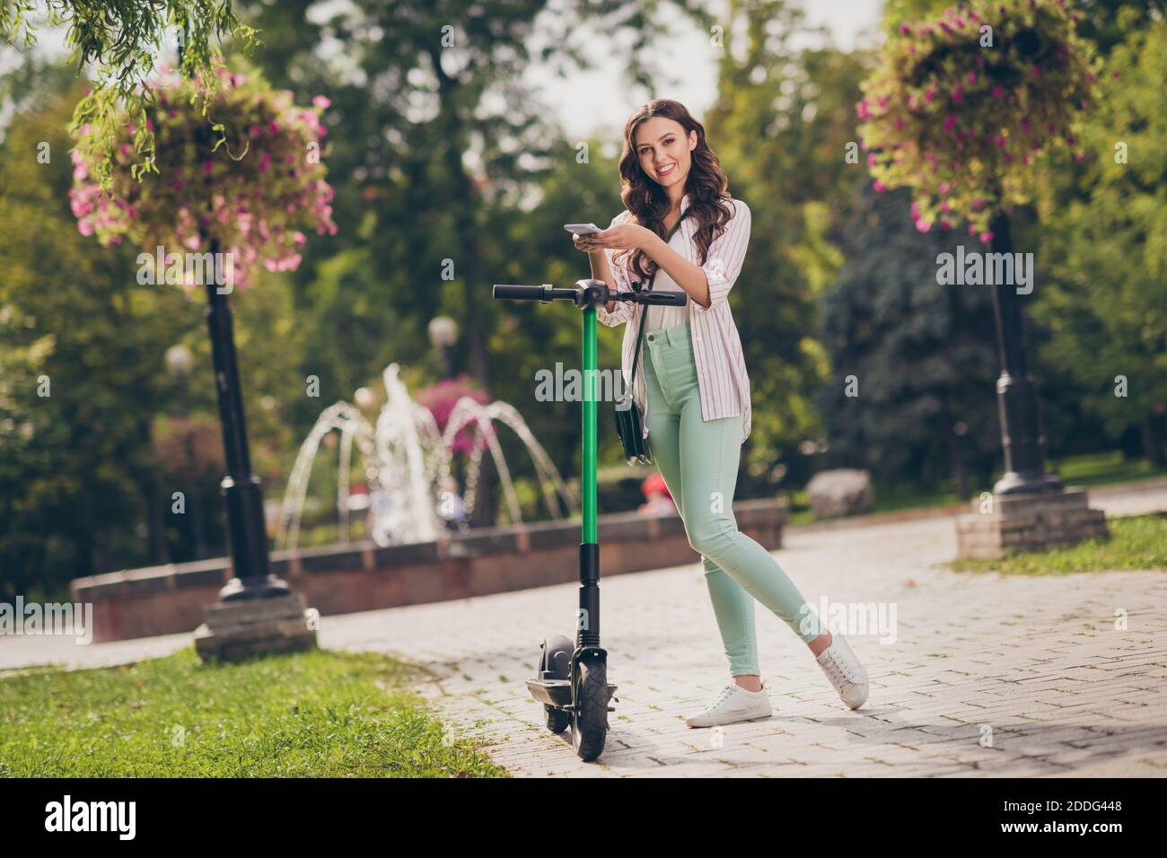 Foto de tamaño completo de encantadora mujer de pelo ondulado explorar  segway por teléfono vestir camisa a rayas pastel verde pantalones zapatos  disfrutar fin de semana fuera Fotografía de stock - Alamy