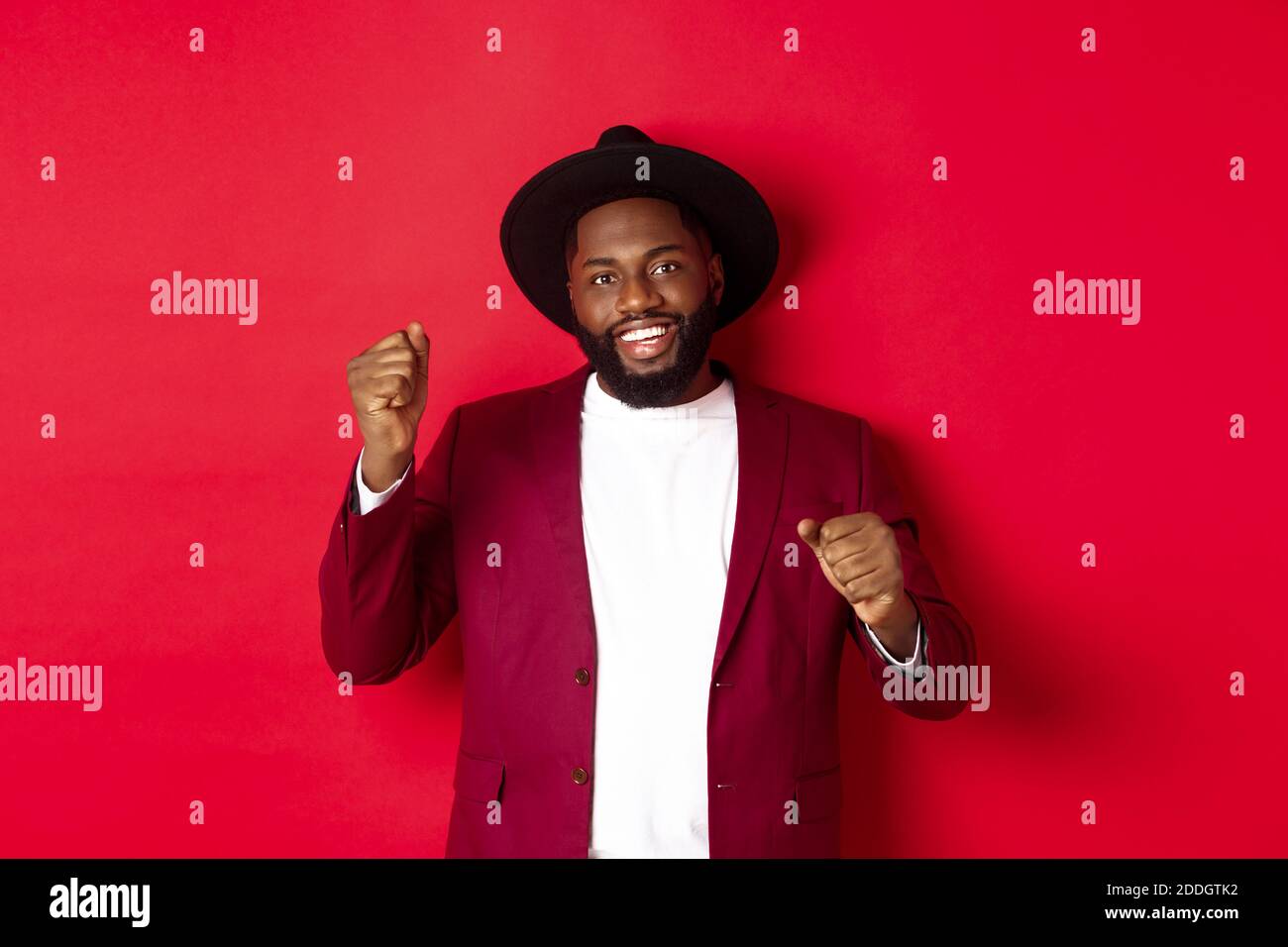 Concepto de moda y fiesta. Hombre negro guapo celebrando en chaqueta y jat,  bailando y divirtiéndose, parándose sobre fondo rojo Fotografía de stock -  Alamy